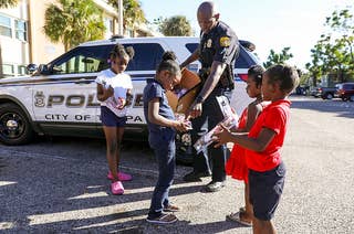 Officer Jerry Wyche interacts with several children outside in Tampa